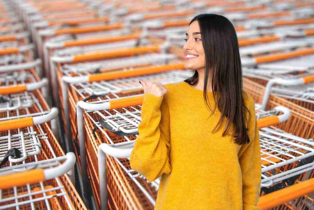 donna che indica carrelli del supermercato